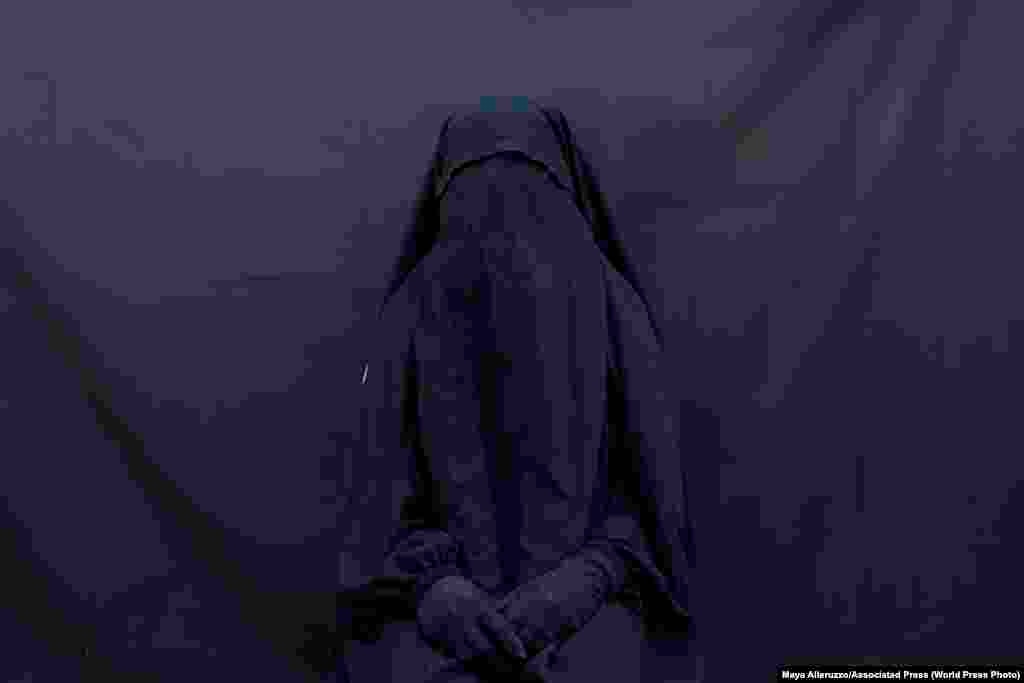 Частина серії «Єзиди, що вижили в так званій «Ісламській державі». Лейла Талу позує для фотопортрету в своєму будинку в Шаріа, Ірак, 9 вересня 2019 року, в чадрі, яка закриває обличчя, і абаї, які вона носила, коли протягом двох з половиною років перебувала в рабстві у бойовиків угруповання «Ісламська держава».   Сучасні проблеми: друга премія, історії – Майя Аллеруццо, Associated Press