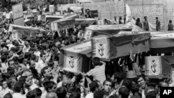 Nošenje kovčega ulicama Teherana na masovnoj sahrani žrtava pada aviona Iran era koji je u Perzijskom zalivu oborila američka krstarica, 7. jul 1988.