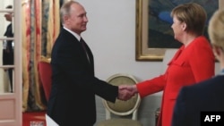 Russin President Vladimir Putin (left) and German Chancellor Angela Merkel shake hands during a bilateral meeting on the sidelines of the G20 in Buenos Aires.