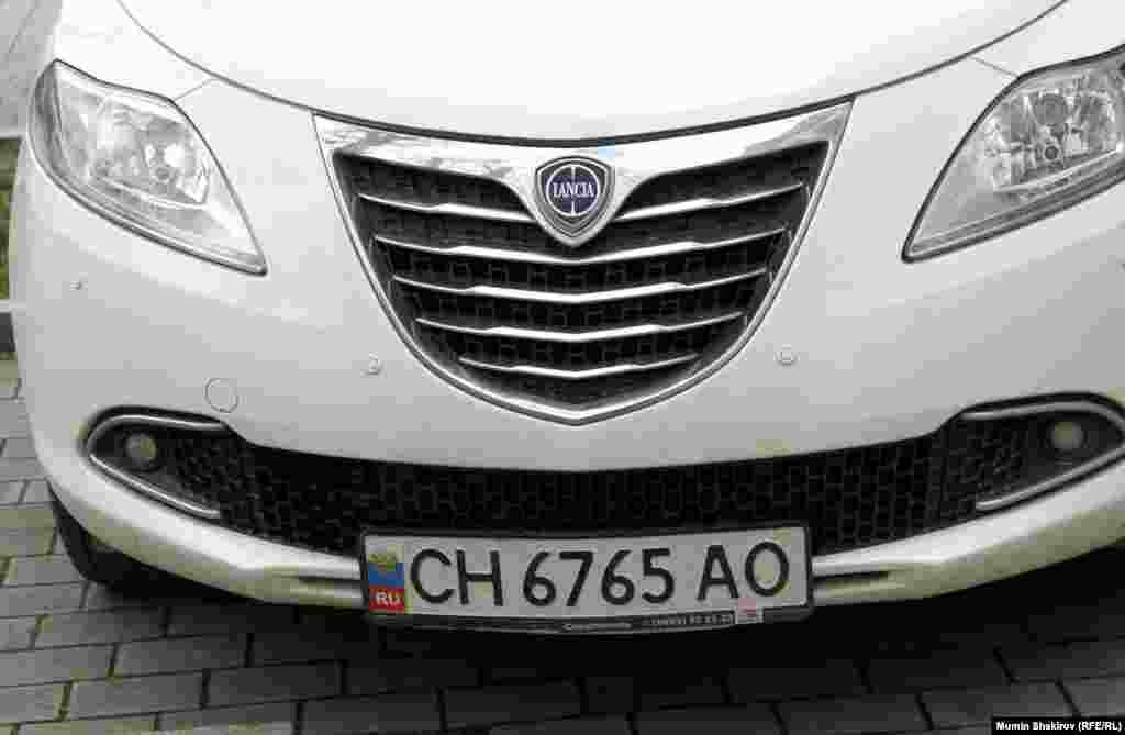 А это крымско-российский патриотизм. На украинский номерной знак наклеивается триколор.  