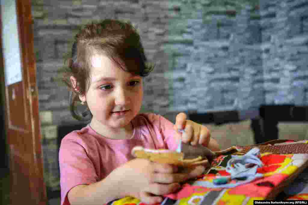 Аят, младшая дочь фигуранта первого симферопольского «дела Хизб ут-Тахрир» Узеира Абдуллаева, играет у себя дома на кухне. Ее отец и дядя были арестованы в один день. Родной брат Узеира Теймур больше года находится в штрафном изоляторе колонии и, как рассказала его мать, находится «в критическом состоянии». «Краткосрочное свидание с Теймуром привело меня в шок. Я увидела своего сына измученным, на нем не было лица – одни кожа и кости, как из концлагеря. Отекшее лицо, желтые глаза... Живого места нет», – рассказала женщина. В июне 2019 года Узеира Абдуллаева приговорили к 12 годам и 6 месяцам заключения