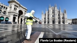 Работник в защитной одежде дезинфицирует площадь Пьяцца-дель-Дуомо в Милане, 31 марта 2020 года