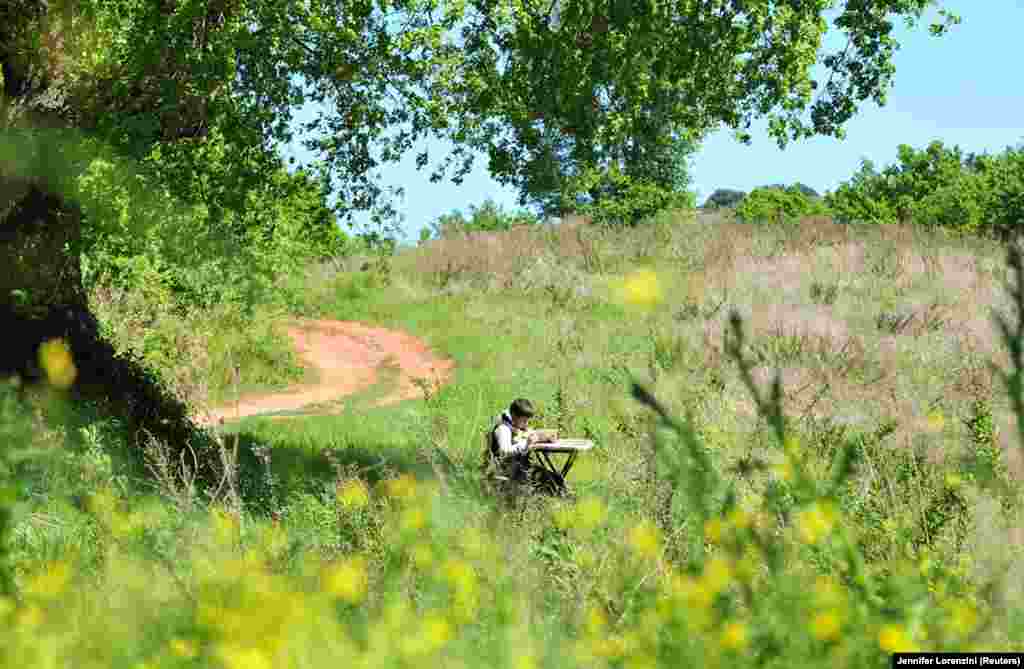 Джуліо Джованніні знайомиться з навчальним матеріалом, дивлячись на екран планшету. Школяр заліз на вершину пагорба неподалік від його рідного міста Скансано, в центральній частині Італії, щоб скористатися надійним 3G-інтернетом для доступу до онлайн-уроків 