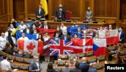 Депутати у Верховній Раді тримають державні прапори країн-партнерів України, щоб висловити свою вдячність за політичну підтримку та військову допомогу Українській державі. Київ, 1 лютого 2022 року