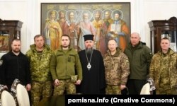 Глава ПЦУ Епіфаній із представниками силових відомств України, 20 квітня 2022 року. Поряд із ним: тодішній командувач Сухопутних військ ЗСУ Олександр Сирський, його заступник Олександр Голоднюк, начальник ГУР Кирило Буданов, командувач Нацгвардії Юрій Лебедь, заступник голови Нацполіції Олександр Фацевич і генерал-майор СБУ Олександр Куць