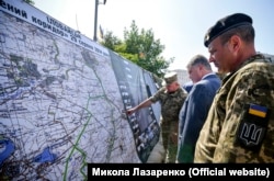 Київ, 23 серпня 2018 року. П'ятий президент України Петро Порошенко дивиться на мапу так званого «зеленого коридору» під Іловайськом, у якому 29 серпня 2014 року регулярні російські підрозділи впритул розстріляли колону українських добровольців