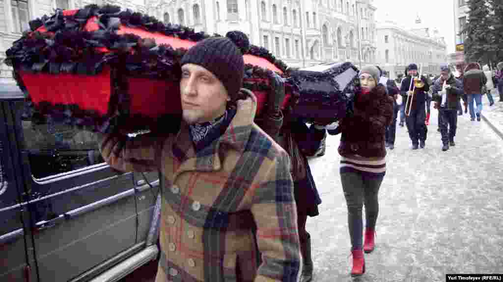 Траурная процессия прошла по улице Ильинка: несколько человек несли гробы с надписями "Профилактика" и "Лечение", оркестр играл траурный марш. 