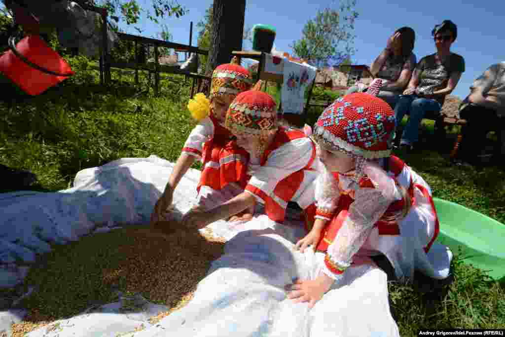 Младшее поколение тоже здесь: три девочки в красивых национальных нарядах внимательно наблюдают за происходящим. Когда-нибудь и они будут варить традиционное чувашское пиво.  