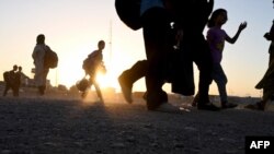 Avganistanske izbeglice nose svoje stvari dok stižu na nultu tačku graničnog prelaza Islam Kala između Avganistana i Irana 28. juna 2025. godine, nakon deportacije iz Irana.