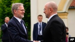 Прем’єр-міністр ЧехіїПетр Фіала (ліворуч) вітає свого українського колегу Дениса Шмигаля під час зустрічі для обговорення співпраці у сфері безпеки у Празі, Чехія, 28 травня 2024 року