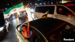 Devojčica drži sirijsku zastavu dok ljudi slave nakon što je američki predsednik rekao da će narediti ukidanje sankcija Siriji, Damask, 13. maja 2025.