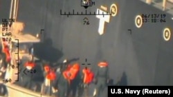 "Стражи исламской революции" снимают мину с борта японского танкера. (Фото, сделанное с борта американского военного вертолета)
