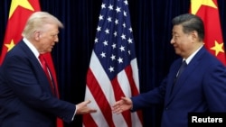 US President Donald Trump and Chinese leader Xi Jinping greet each other as they arrive for talks in Busan on October 30.