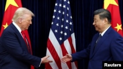 Президентът на САЩ Доналд Тръмп и китайският лидер Си Цзинпин се поздравяват при пристигането си за преговори в Пусан на 30 октомври.