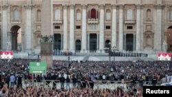 Люди на площади около собора св. Петра снимают на телефоны первую речь нового папы римского, Роберта Фрэнсиса Прево, 8 мая 2025 года