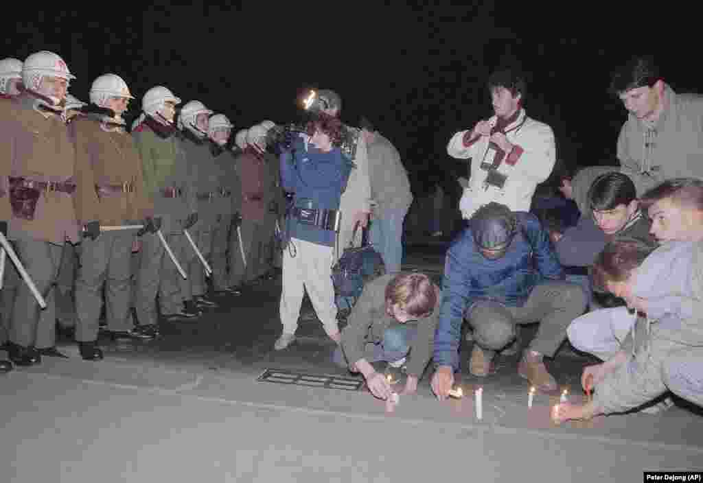 People light candles in front of a line of riot police who had stopped protesters from crossing a bridge on November 21. 