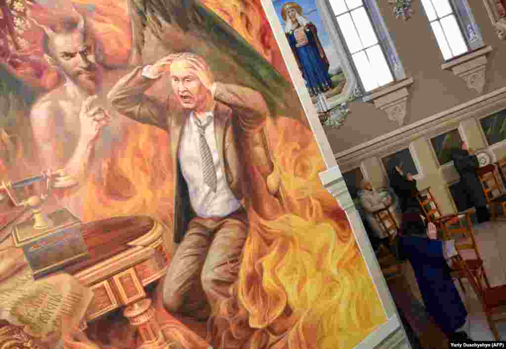 Прихожани моляться у церкві святого Йосафата УГКЦ в місті Червонограді, де на одній із фресок на тему «Страшний суд» зображений персонаж, в якому більшість людей впізнають російського президента Володимира Путіна. За задумом семи авторів, які розписували стіни у церкві в Червонограді, ними намальований збірний образ грішника-політика, який робить чимало лиха у світі. Червоноград, Львівська область, 6 лютого 2019 року