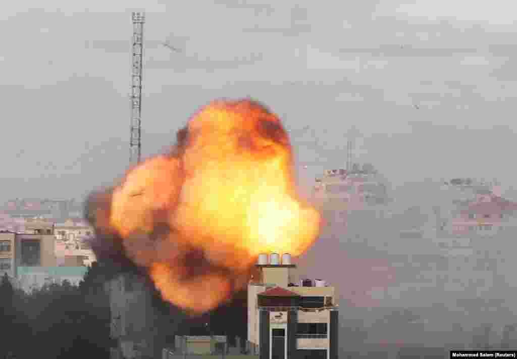 Видно дим і полум'я після авіаудару Ізраїлю по будівлі в місті Газі 18 травня 2021 року. Нинішнє збройне загострення ризикує спровокувати гуманітарну катастрофу: за даними ООН, понад 38 тисяч палестинців були переміщені в Газі, а ще 2500 втратили свої будинки