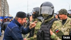 Учасник мітингу і співробітники російської поліції на центральній площі Аланія Мітингувальники виступають проти угоди про встановлення адміністративного кордону між Інгушетією та Чеченської республікою. Основна вимога протестувальників - винести питання про встановлення кордону на референдум. 26 вересня 2018 року глави Інгушетії і Чечні Юнус-Бек Євкуров і Рамзан Кадиров підписали договір про закріплення адміністративного кордону між регіонами, яка не була чітко встановлена з часів розпаду Чечено-Інгушської АРСР в 1991 році.