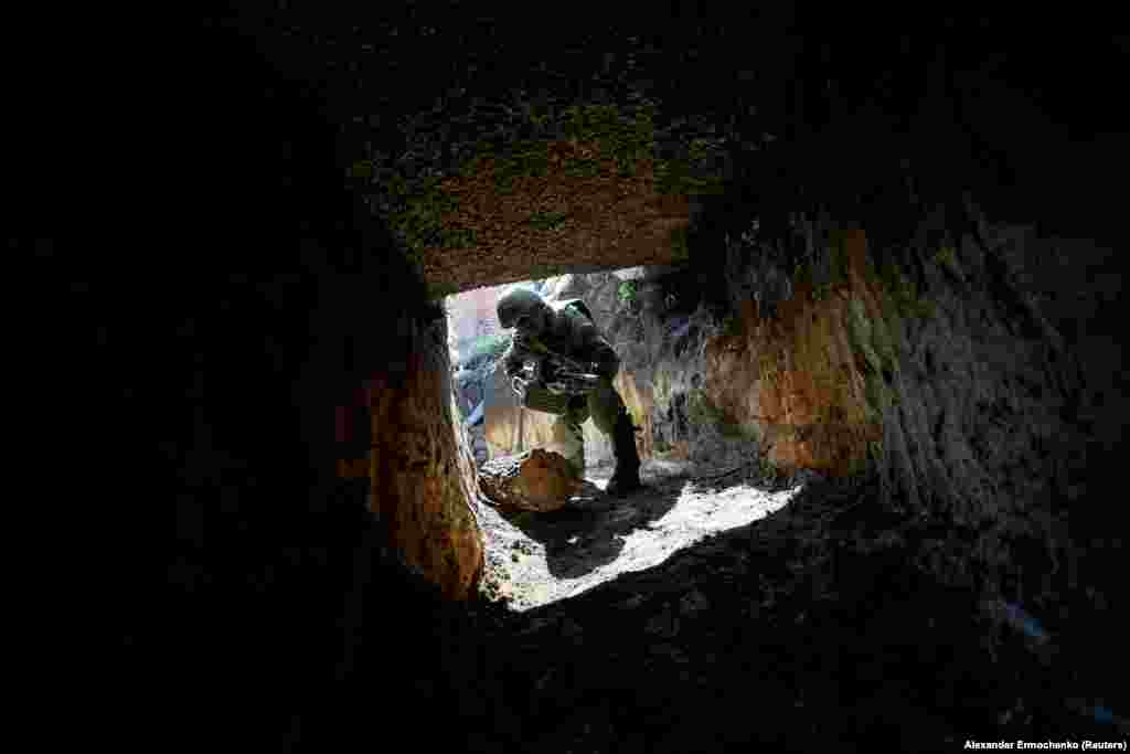 Бойовик російських гібридних сил займає позицію біля лінії зіткнення з українськими військовими в Донецькій області. (Reuters/Alexander Ermochenko)