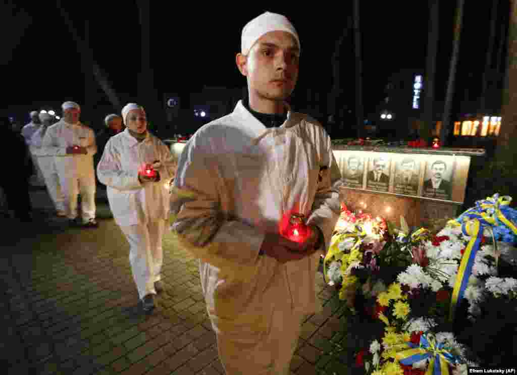 Працівники ЧАЕС в уніформі під час церемонії вшанування пам’яті жертв аварії біля меморіалу загиблим пожежникам та ліквідаторам аварії на ЧАЕС. Славутич, 26 квітня 2019 року.  