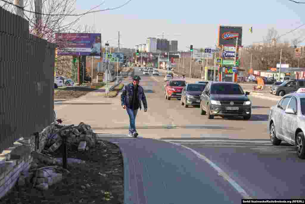 Люди пішки, прикрившивсь білим, виходять із Бучі.Ліворуч фото від 11 березня 2022, праворуч – Бберезень 2025 року