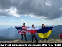 Волонтери Марцін Пйотровський і Марек Скулімовський з сином на вершині Говерли