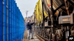 Un polițist de frontieră român verifică un tren de marfă cu combustibil la punctul de trecere feroviară a frontierei dintre România și R. Moldova, în Ungheni, România, pe 18 ianuarie 2011.