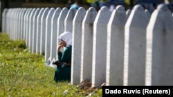 A woman mourns among graves at a Memorial Center near Srebenica for some 8,000 people who were killed in a massacre there during the Bosnian War. Srebrenica had been declared a safe zone by the United Nations at the time.