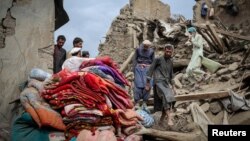 Afganistanski muškarci hodaju po ruševinama oštećene kuće nakon smrtonosnog zemljotresa jačine 6 stepeni Rihterove skale koji je pogodio istočni Afganistan, septembar 2025.