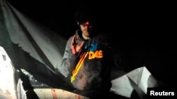 Dzhokhar Tsarnaev is shown before his arrest with a sniper's laser sight trained on his head as he surrenders to authorities on April 19, 2013, after a massive manhunt.