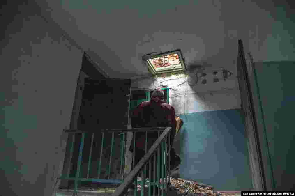 Валентина Іванівна біля своєї квартири, яка знаходиться на п'ятому поверсі. Через те, що снаряди влучили у дах, зверху постійно осипається бита цегла