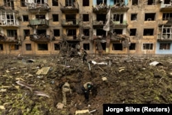 Українські військові оглядають місце ракетного удару біля житлового будинку в українському Добропіллі Донецької області, 30 квітня 2022 року