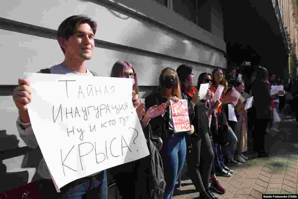 На фото: хлопець тримає плакат із написом: «Таємна інавгуація? Ну, і хто тут щур?»