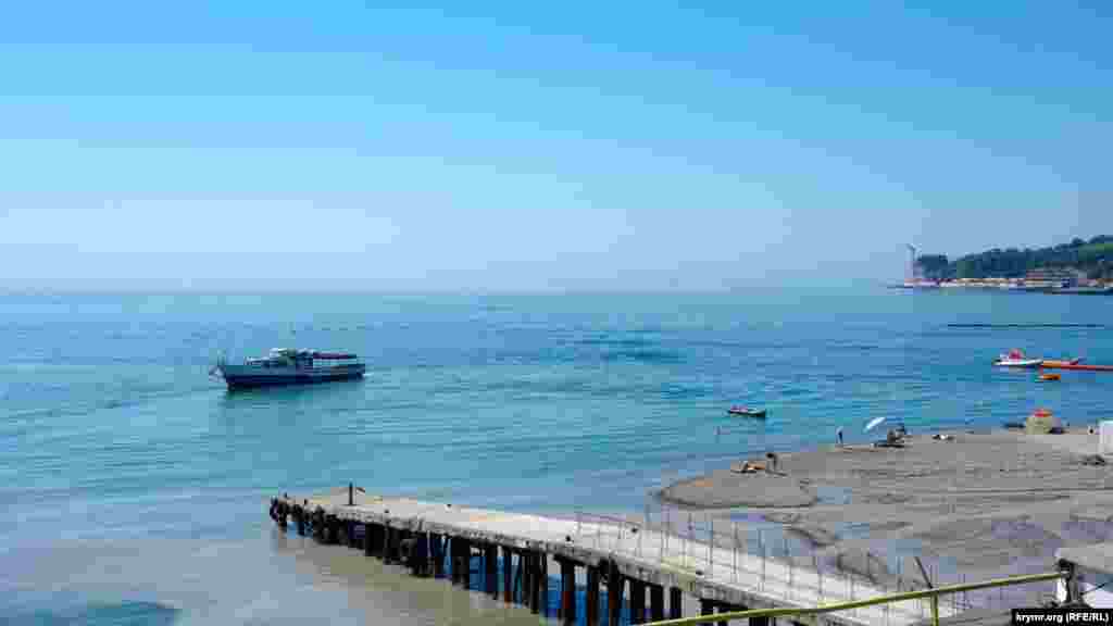 Мутное устье реки у старого пирса, к которому причаливает прогулочный теплоход за  экскурсантами