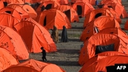 Afganistanke hodaju pored šatora nakon dolaska iz Pakistana u improvizirani kamp blizu graničnog prelaza Torkham između Afganistana i Pakistana u provinciji Nangarhar 20. aprila.