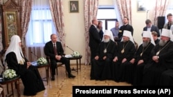 Київ, Києво-Печерська лавра, 27 липня 2013 року. Московський патріарх Кирило (ліворуч), президент Росії Володимир Путін (другий зліва), а напроти учасники синоду УПЦ (МП), серед яких митрополит Онуфрій (другий справа)