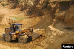 Рабочий управляет скиповым погрузчиком во время работы на шахте по добыче редкоземельных металлов в Наньчан, провинция Цзянси, 31 октября 2010 года