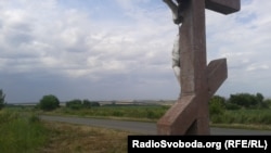 Поклінний хрест у Розсипне з квітами від українців