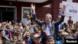 Иоханнес Хан, европейский комиссар по вопросам расширения ЕС встречается с сирийскими детьми в лагере беженцев в Турции