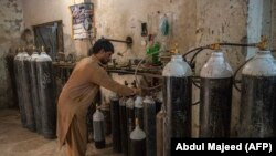 A worker fills oxygen cylinders for hospital use in Peshawar on December 7.