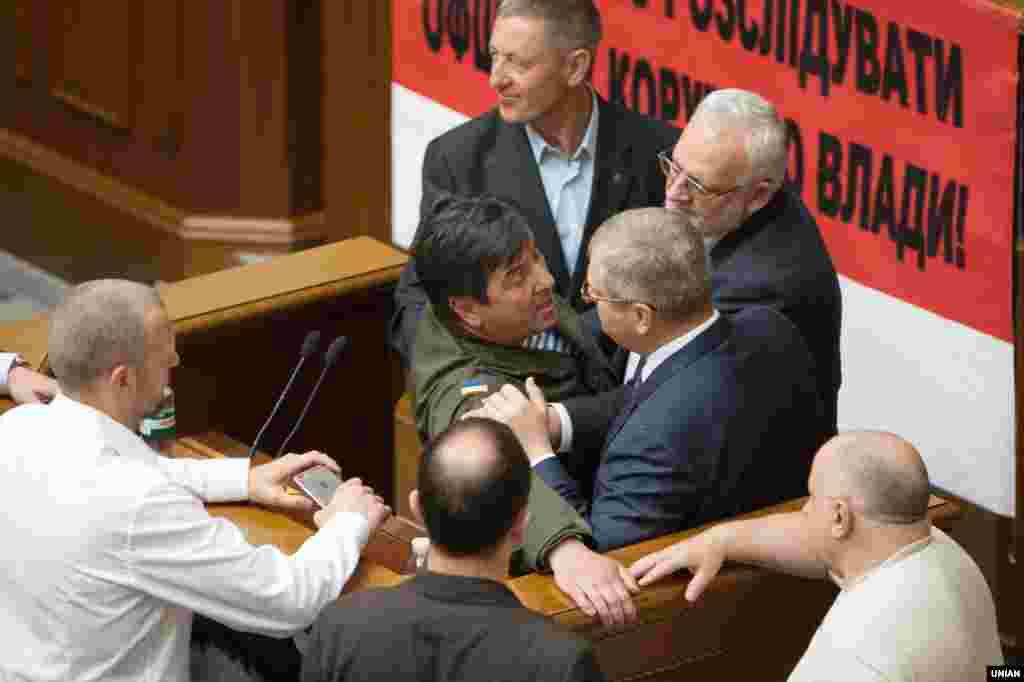 Сутичка між народними депутатами України Юрієм Тимошенком (ліворуч)  від «Народного фронту» та Олександром Вілкулом, заступником голови фракції «Опозиційний блок», виступ якого російською мовою обурив депутатів. Київ, 13 травня 2016 року. Більше про це ТУТ