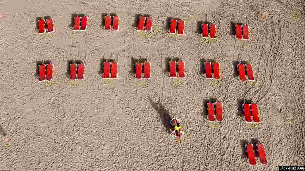 На цьому фото, зробленому 20 травня з пташиного польоту, шезлонги на пляжі в ізраїльському місті Тель-Авів викладені на відстані, з дотриманням фізичної дистанції між відпочивальниками. Пляжі відкриваються вперше після двомісячного карантину завпровадженого через пандемію COVID-19. Тель-Авів, Ізраїль, 20 травня 2020 року