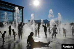 Ljudi se rashlađuju u parku u Parizu, avgust 2016.