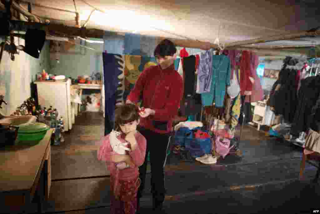 Жінка з донькою в обжитому бомбосховищі лікарні Жовтневого району Донецька, 16 листопада 2014 року