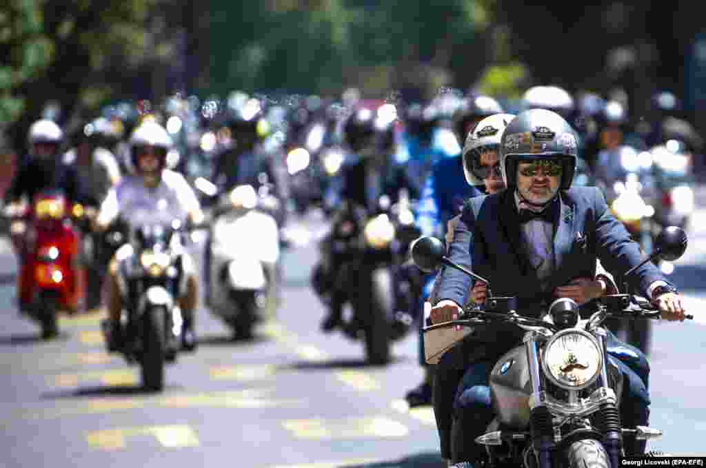 Участники благотворительной акции «Поездка выдающегося джентльмена», посвященной винтажным мотоциклам, катаются по улицам Скопье, Северная Македония, 23 мая