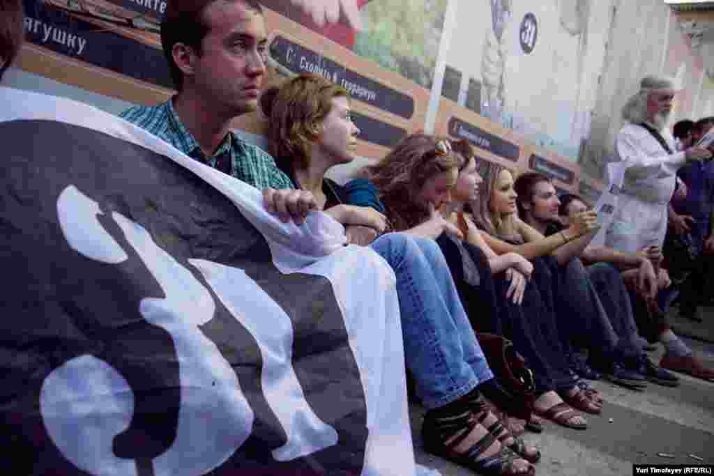 С разных сторон к площади подошли молодые люди, около 50 человек сели у заграждений вокруг  памятника Маяковскому  и стали скандировать  "Долой власть чекистов!", "Нам нужна другая Россия!", "Россия- без Путина!&quo