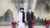 Taliban co-founder Mullah Abdul Ghani Baradar (left) and Chinese Foreign Minister Wang Yi pose for a photo during their meeting in Tianjin on July 28.