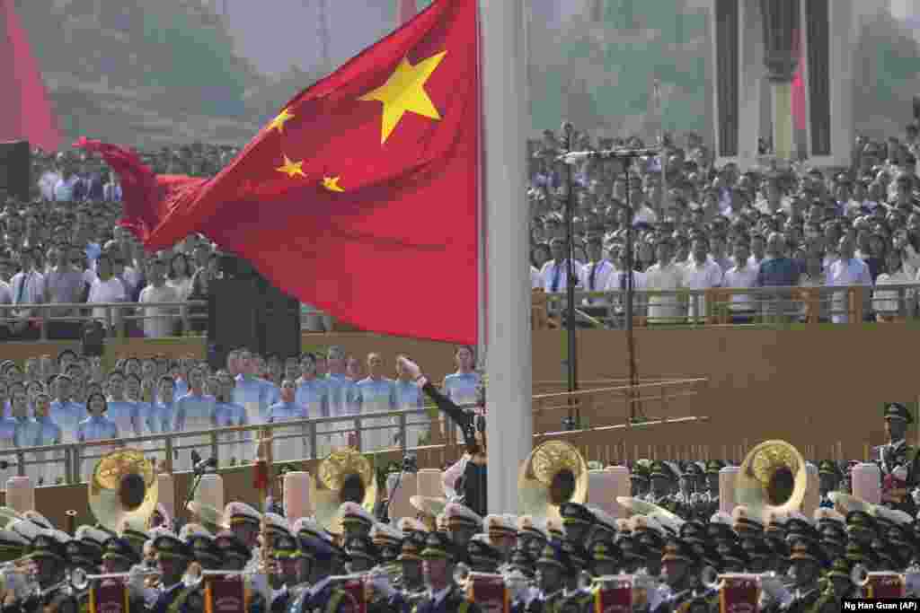 Kineska zastava se podiže prije početka vojne parade.