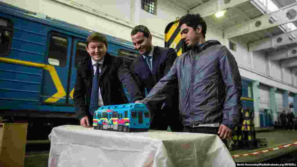 Заступник голови КМДА Ілля Сагайдак, директор КП «Київський метрополітен» Віктор Брагінський та іспанський художник Кенор розрізають торт у вигляді рофарбованого вагону метро